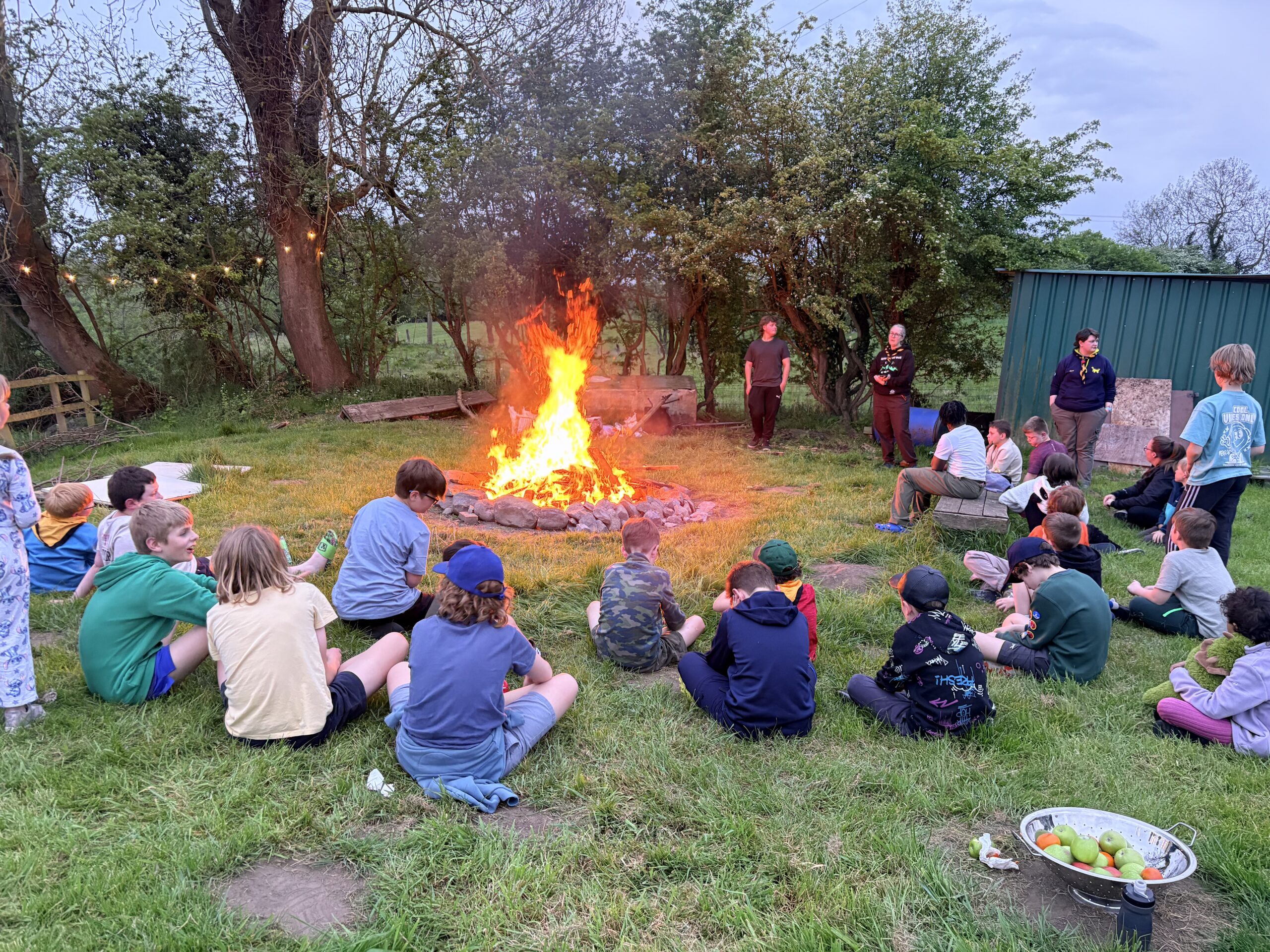 Group of young people sitting round camp fire at Aldwark